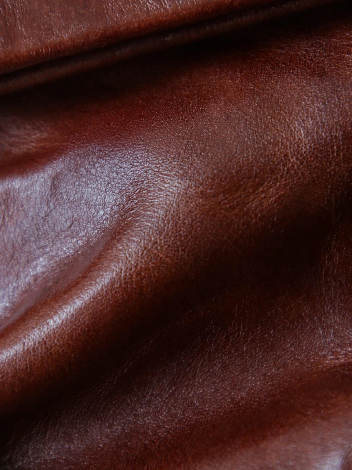 Close-up of the hand-crinkled grain on chestnut brown vegetable-tanned leather