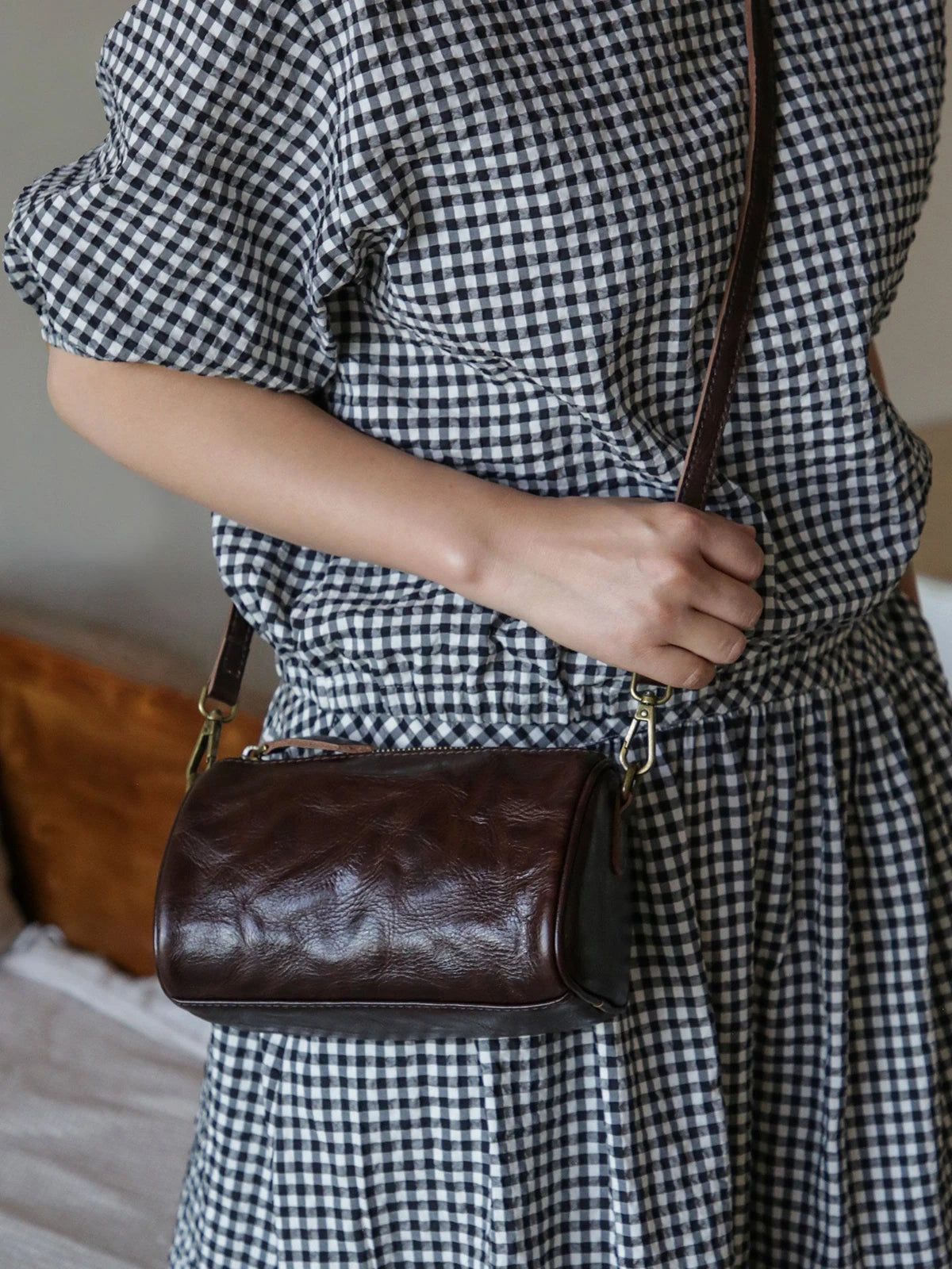 Coffee brown leather barrel bag styled as a crossbody