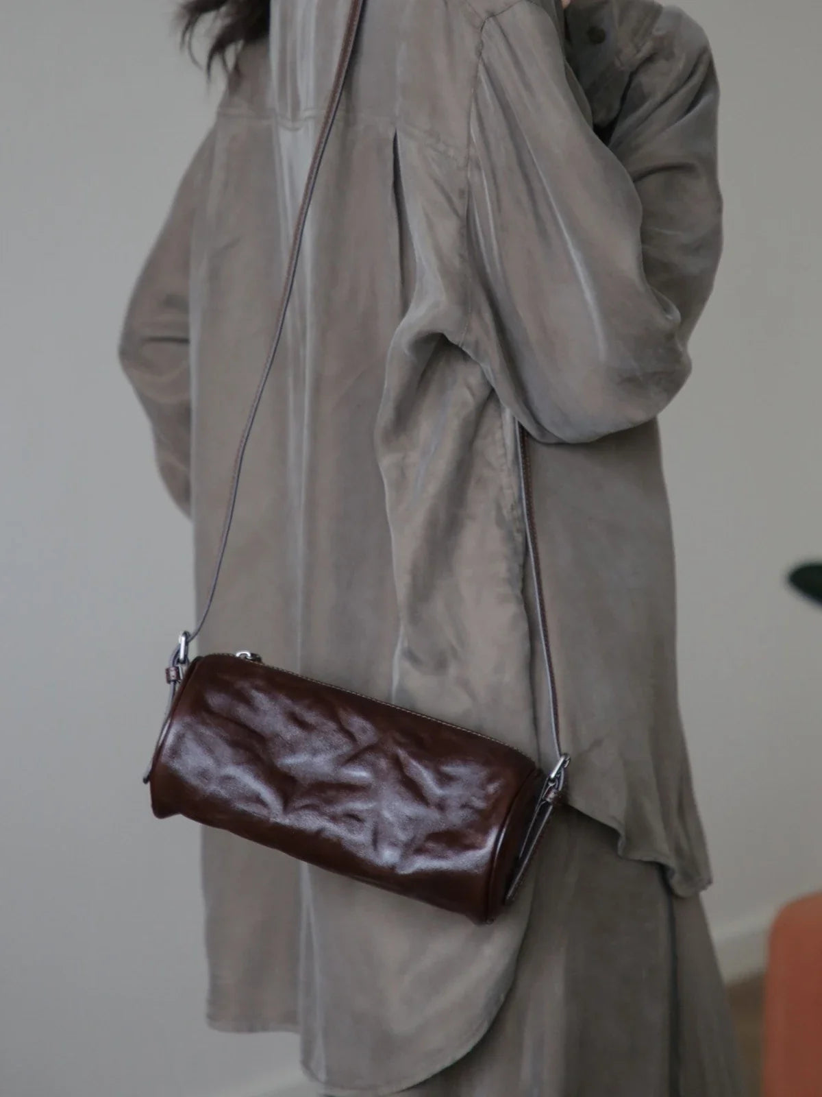 Espresso brown leather barrel shoulder bag worn at the side