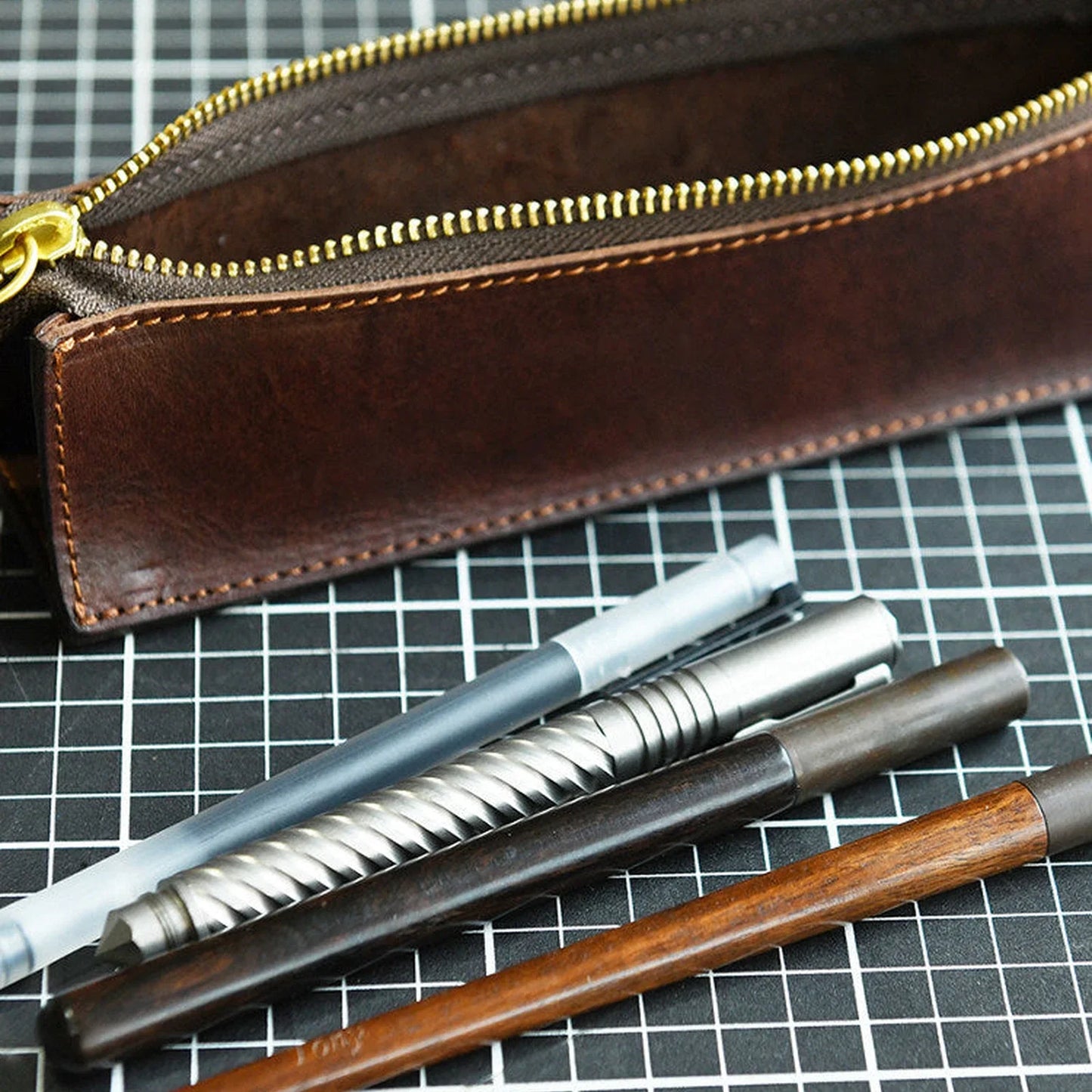 Dark brown leather pencil case with writing tools