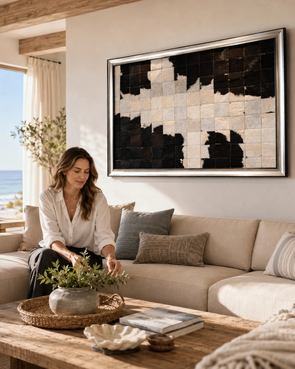 Black and ivory framed cowhide patchwork wall art above a neutral sofa