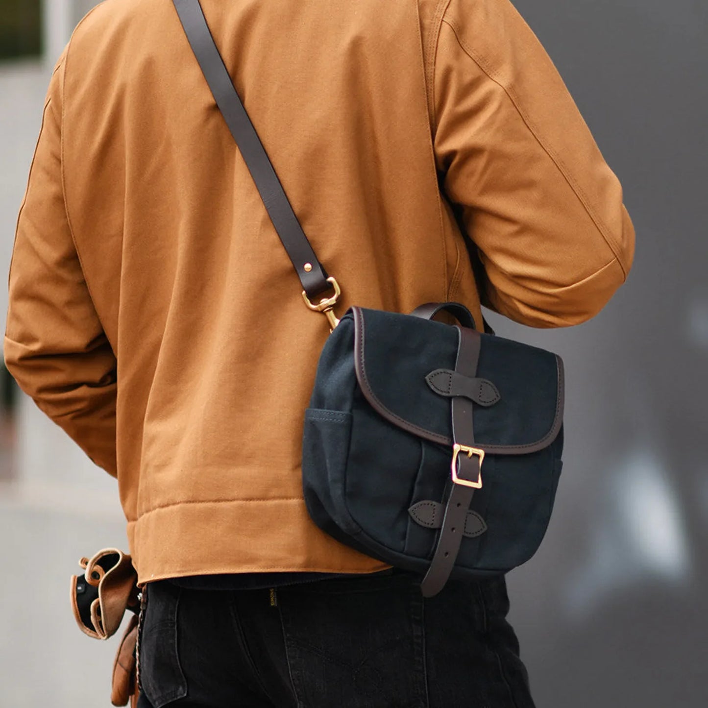 Slate blue waxed canvas messenger bag worn crossbody from the back