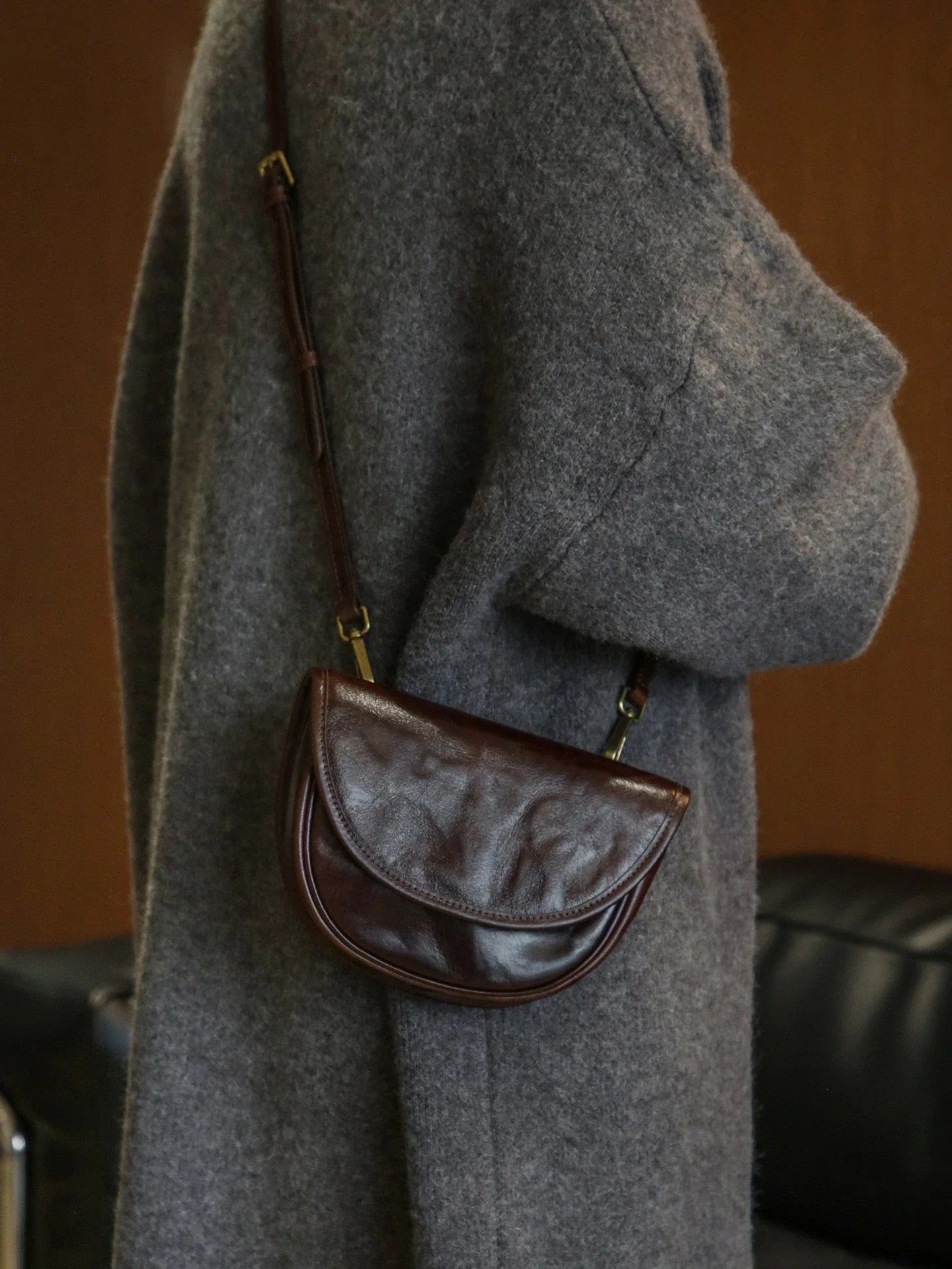 Ebony brown saddle bag showing its curved flap and compact profile