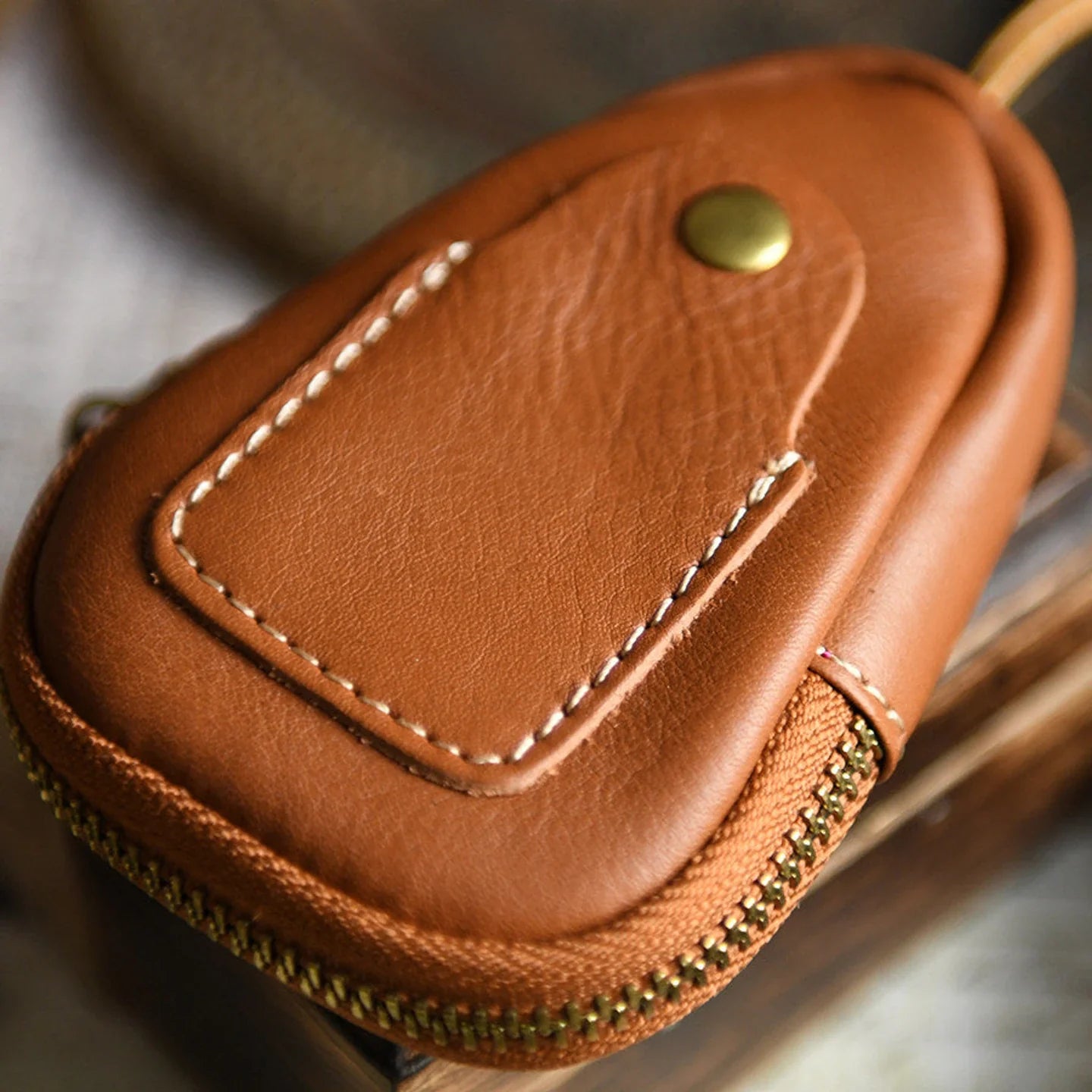 Top-grain leather texture and hand-stitched front pocket detail