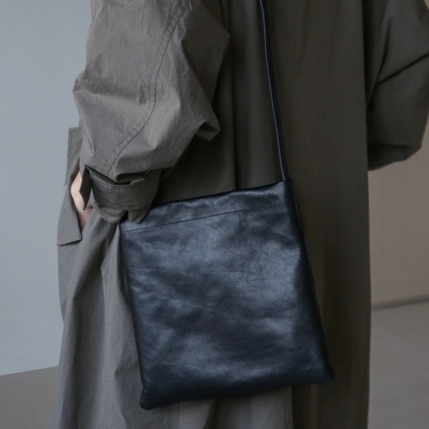 Black leather shoulder bag styled at the hip