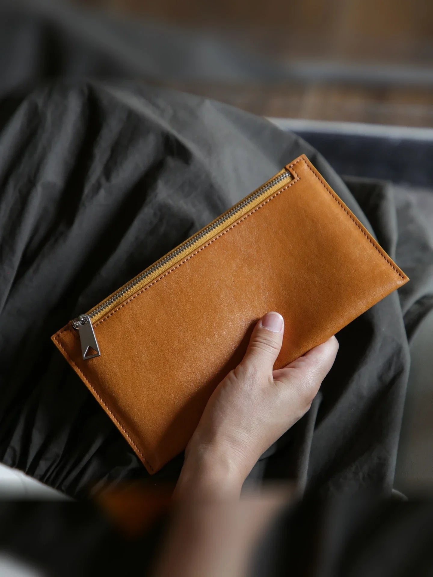 Caramel leather slim long wallet showing the exterior zip pocket