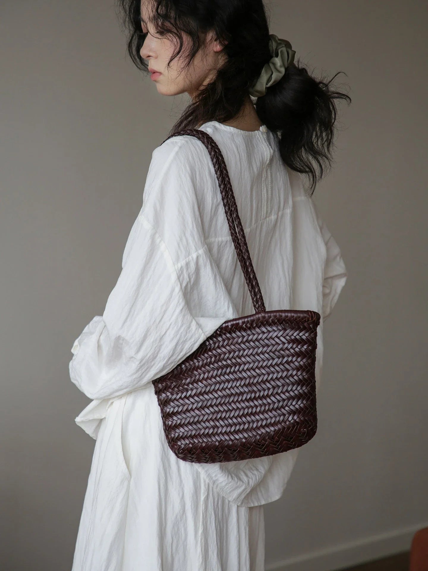 Coffee brown woven leather shoulder bag in a rear three-quarter view