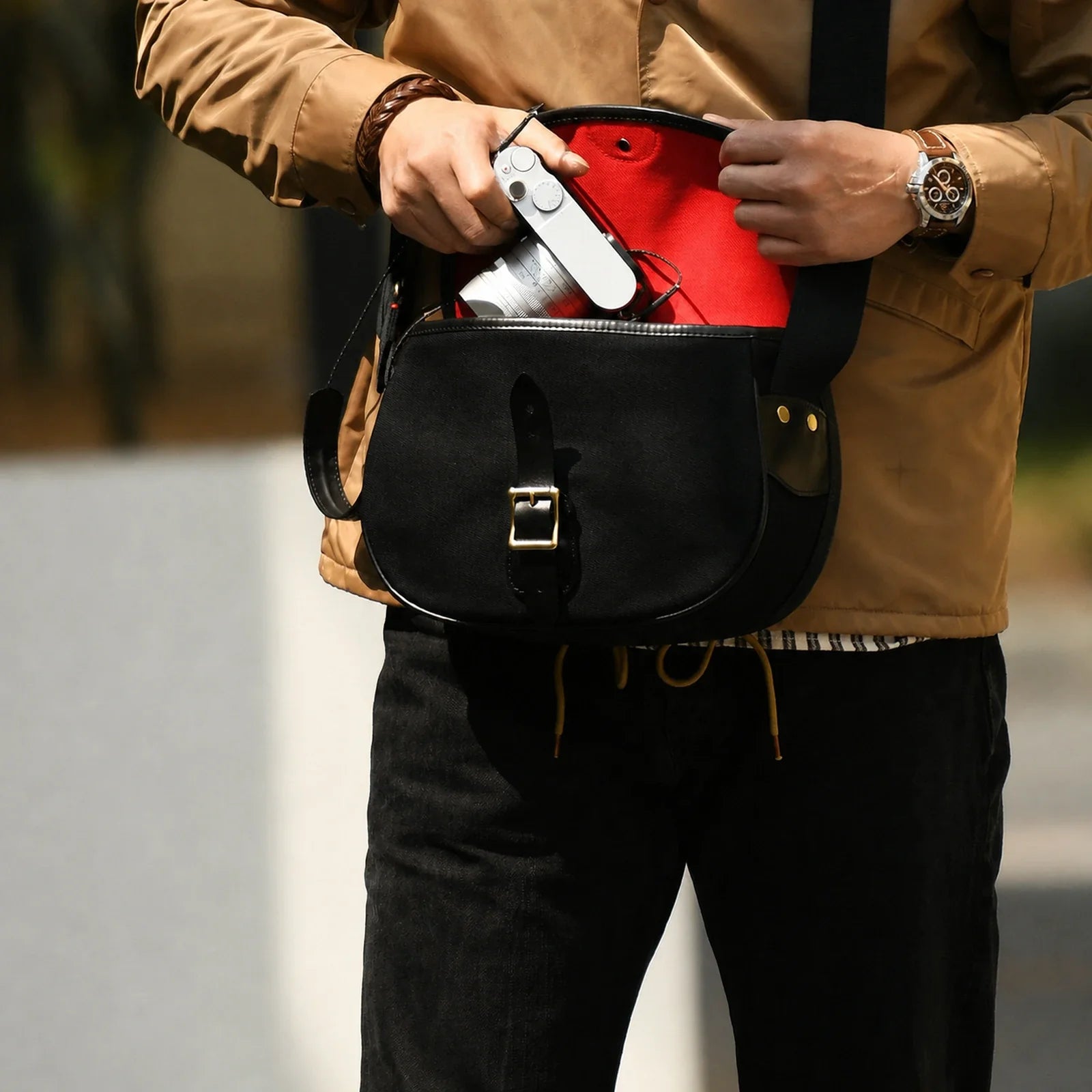 Black camera crossbody bag with red padded interior