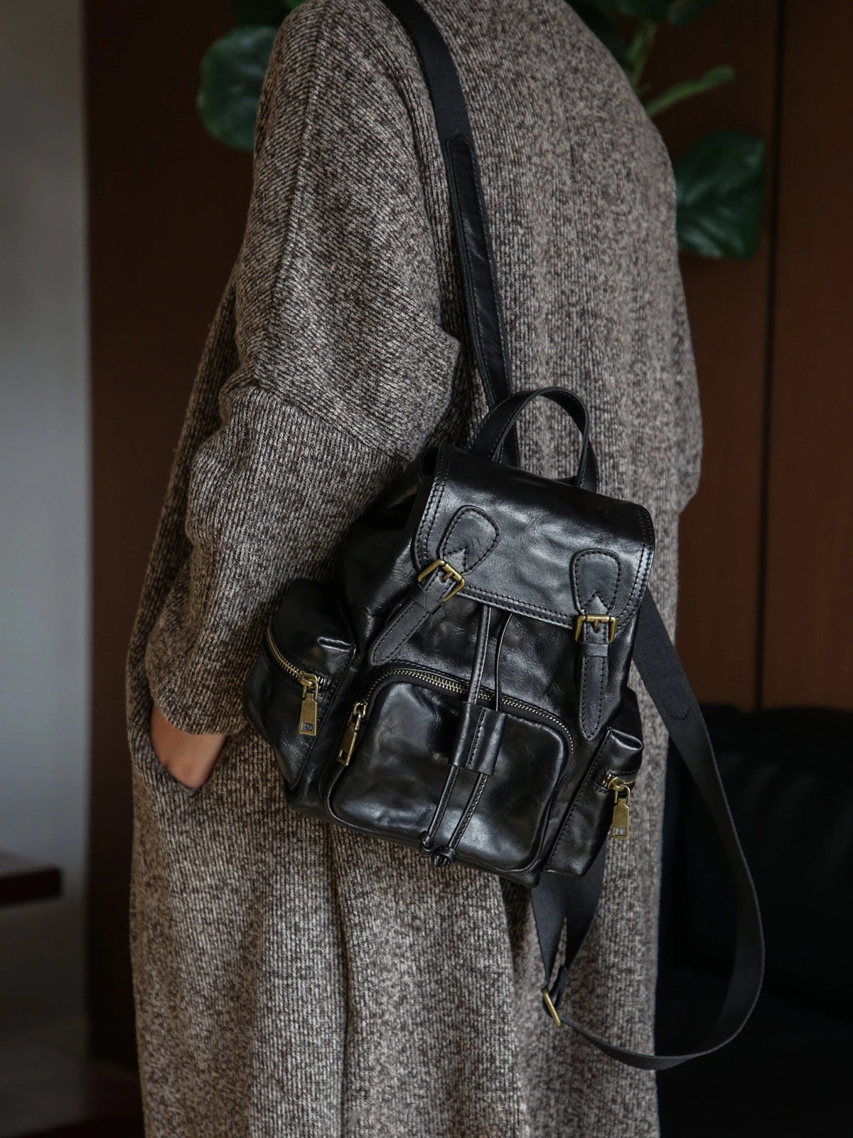 Black vegetable-tanned leather backpack worn on the shoulder