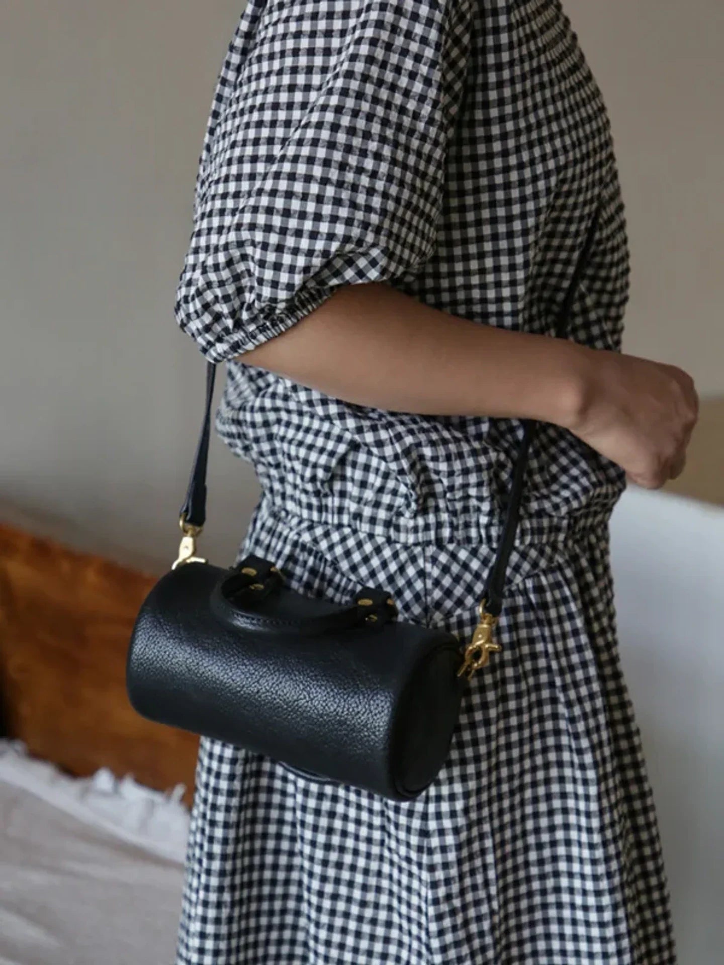 Rear view of the black leather barrel bag and detachable strap