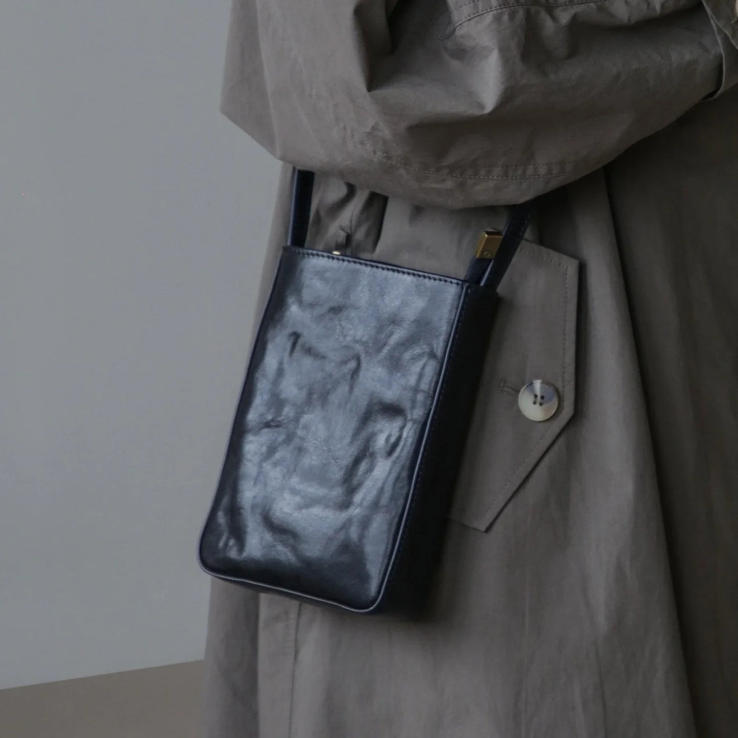 Black leather phone bag, shoulder-worn view