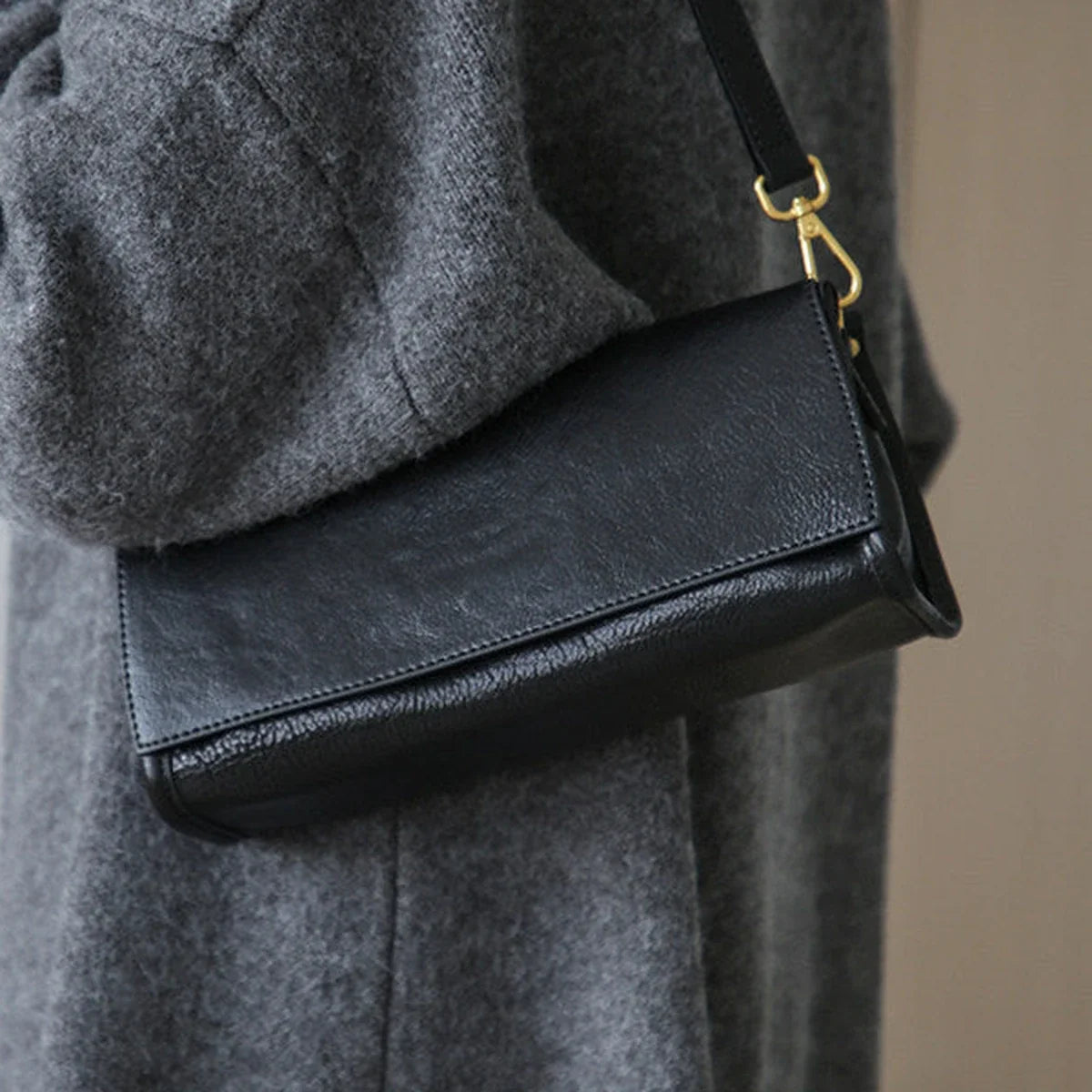 Black leather grain, flap, and gold-tone hardware detail