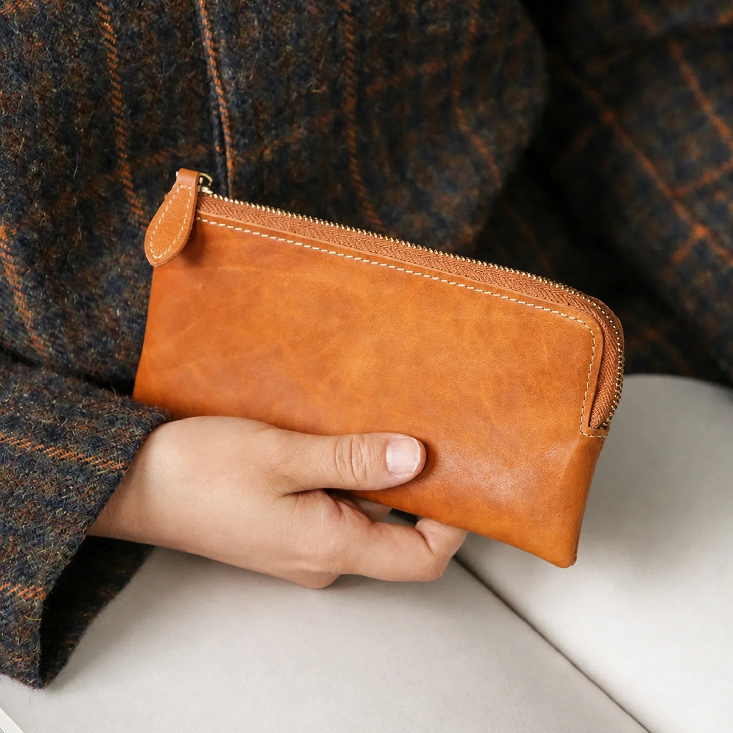 Cognac Brown leather long wallet held in hand