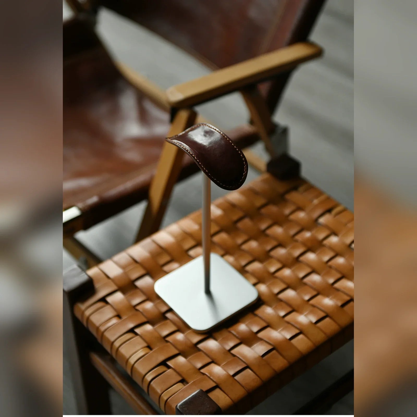 Espresso cowhide and silver metal headphone stand in a chair-side setting