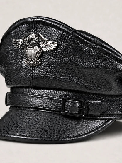 Close view of black cowhide leather grain, stitching, strap and decorative metal badge