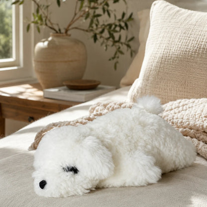 White lambswool poodle pillow on layered neutral bedding