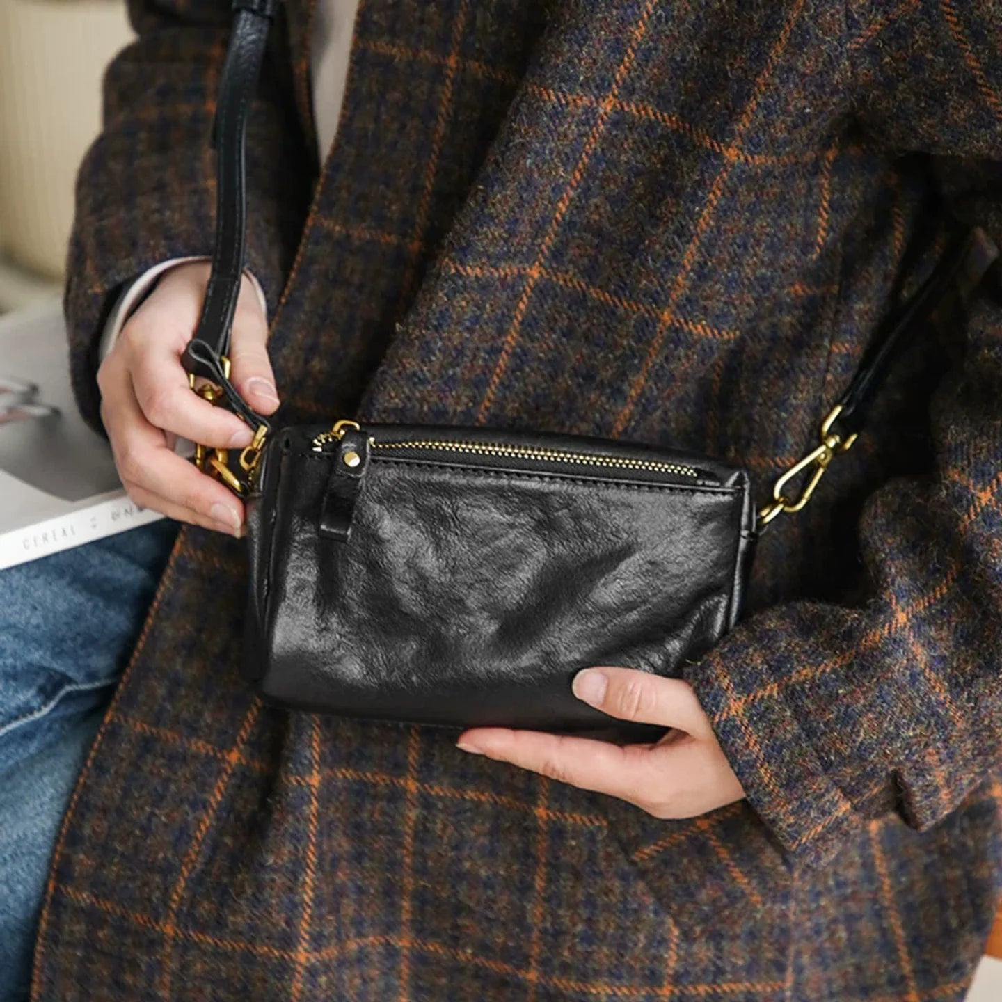 Close-up of the black leather crossbody bag and zipper construction