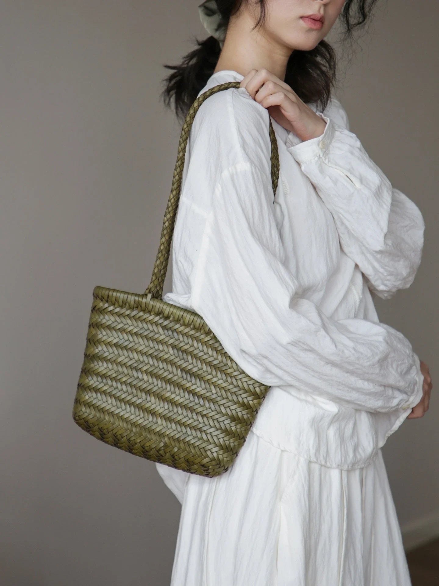 Olive green woven leather shoulder bag in a lifestyle view