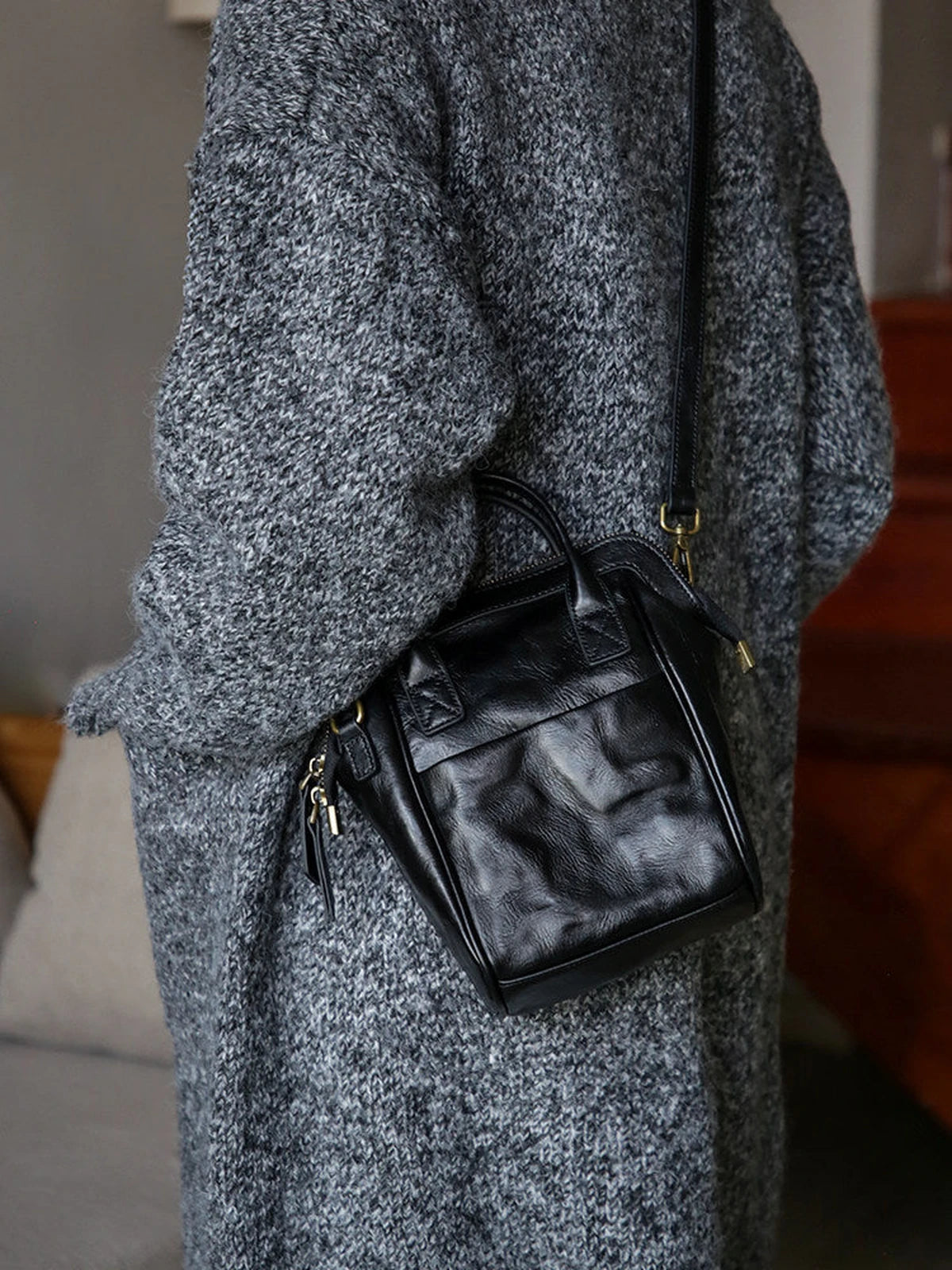 Black leather mini backpack styled as a crossbody bag