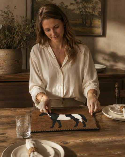 Woman setting a dining table with a brown horse-inlay genuine cowhide placemat