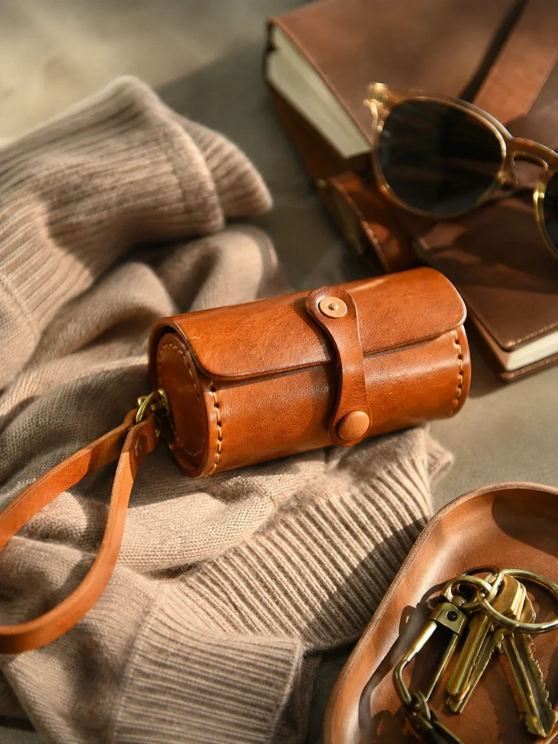 Sunset tan leather wristlet case styled with knitwear and accessories