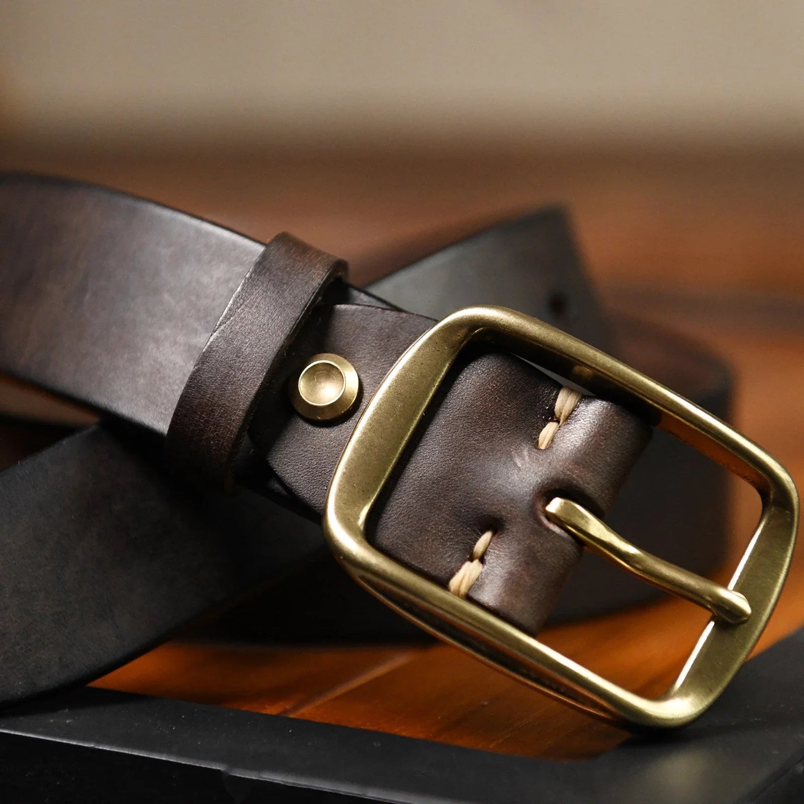 Dark brown cowhide belt buckle and leather keeper detail