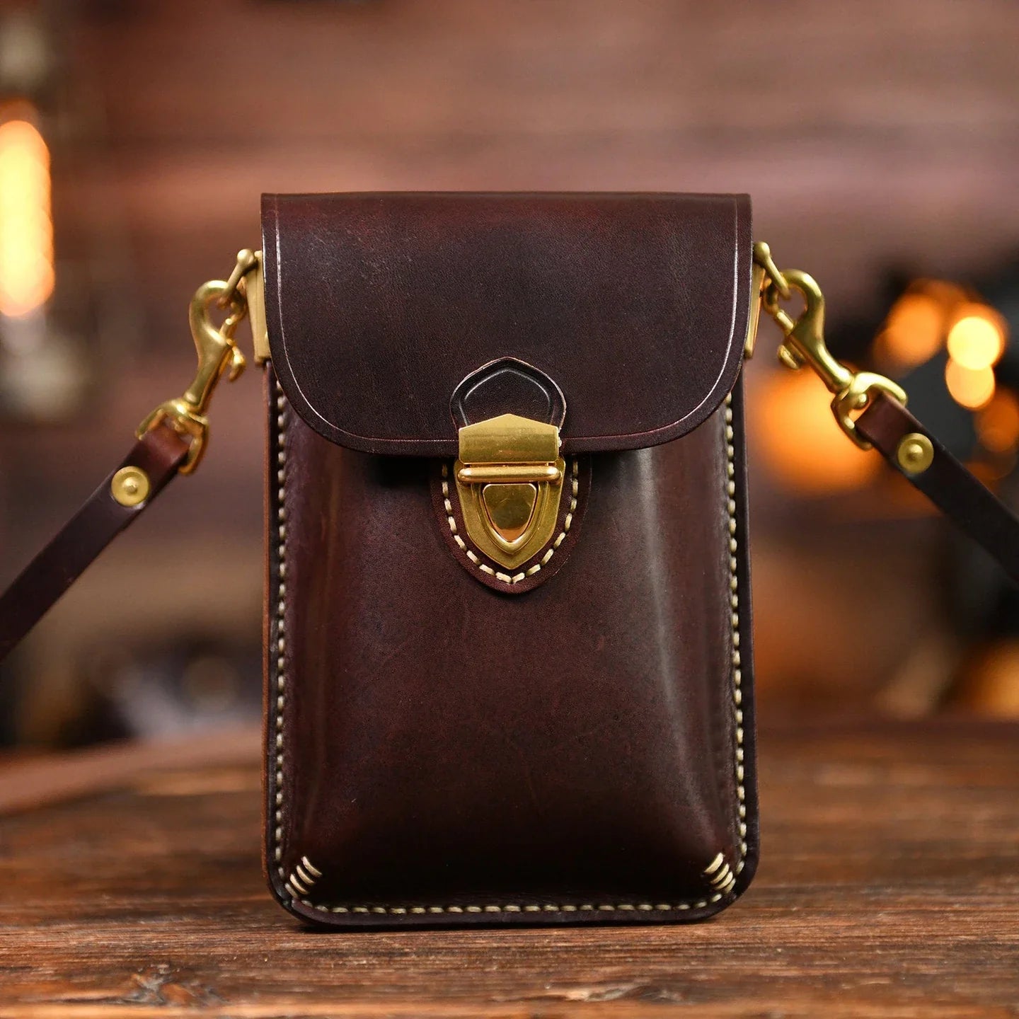 Dark Brown top-grain leather crossbody phone bag on a warm wood surface