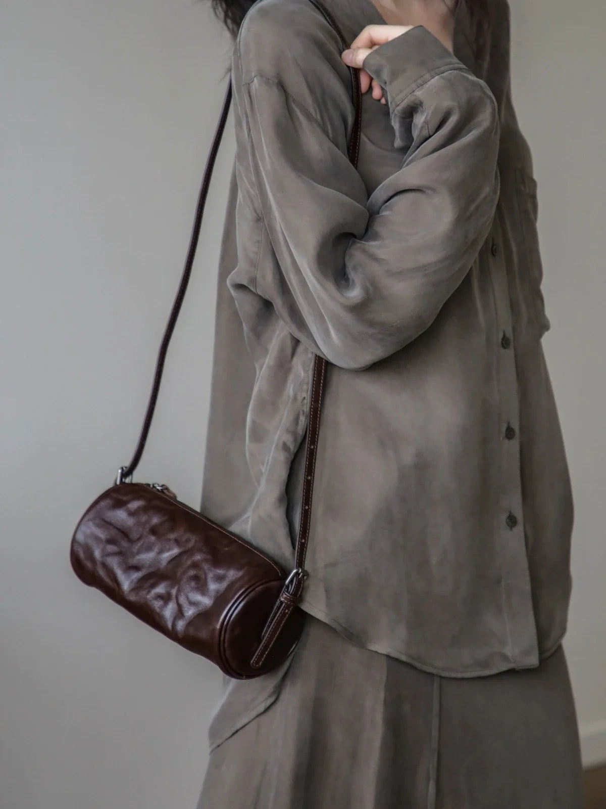 Espresso brown leather barrel bag worn crossbody