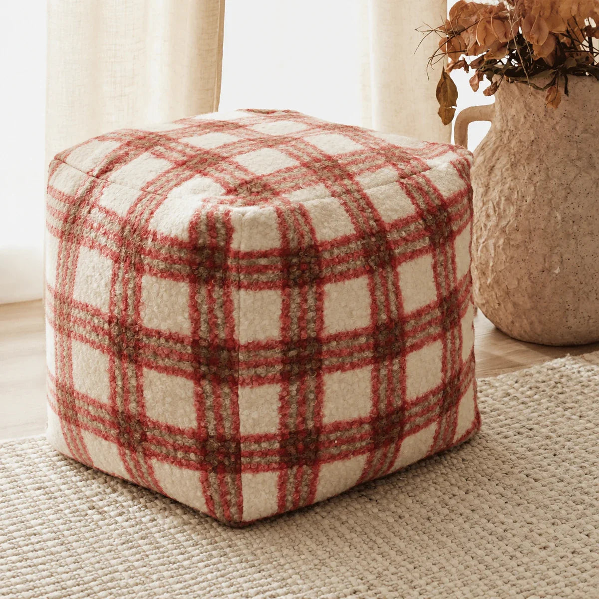 Red plaid textured floor cushion in a neutral interior