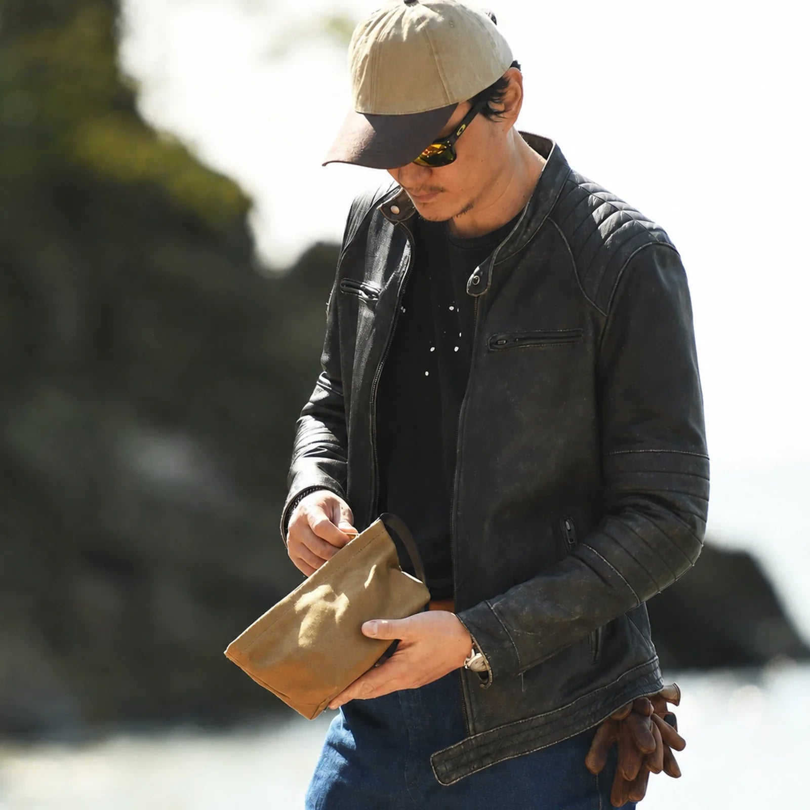 Unbranded lifestyle view of khaki waxed canvas travel pouch
