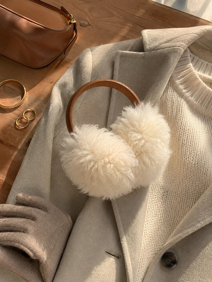 White wool earmuffs with a brown headband styled with neutral winter layers