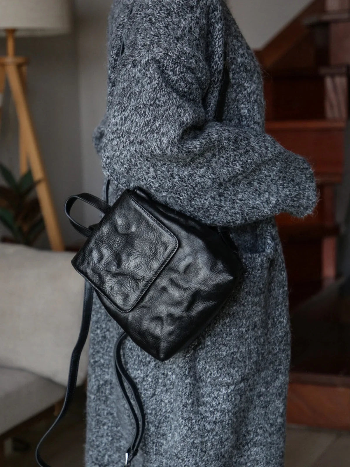 Black mini leather backpack styled with a textured knit coat