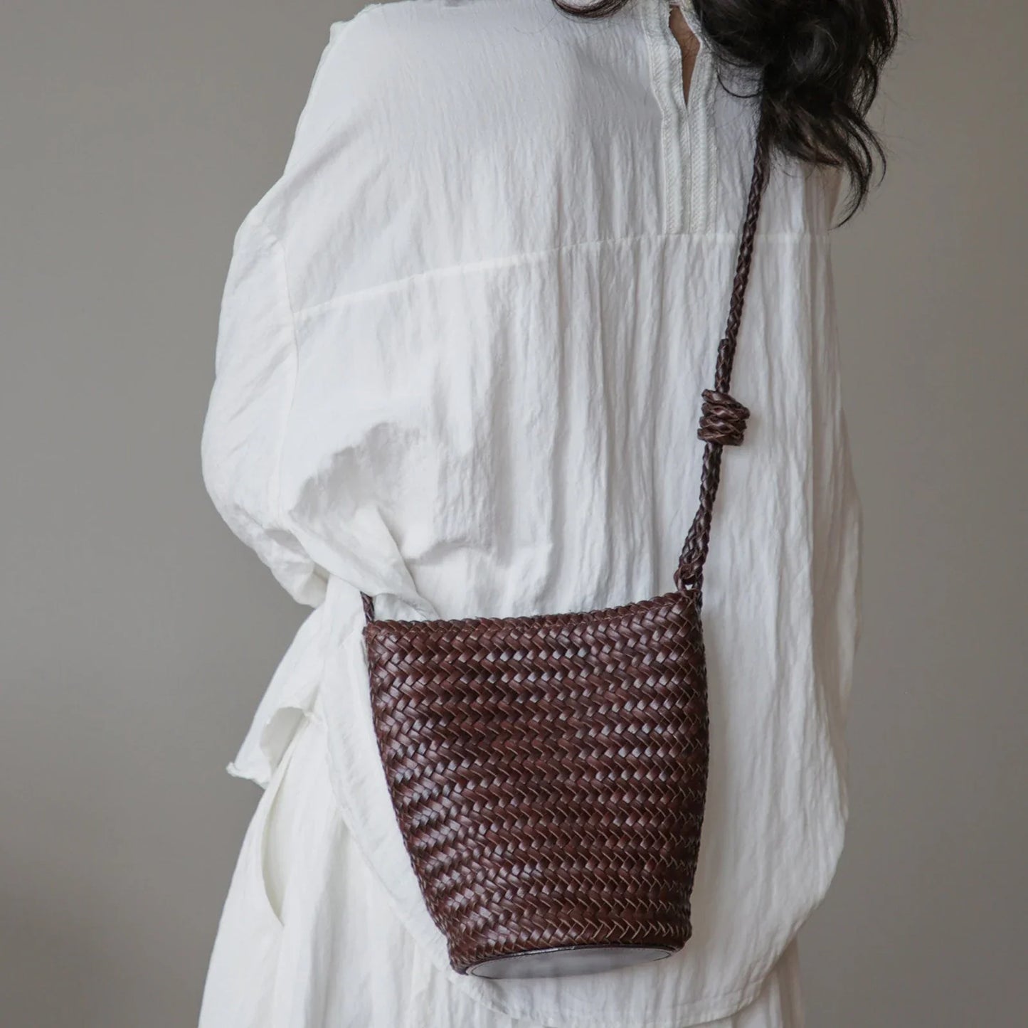 Coffee brown woven leather bucket bag styled crossbody