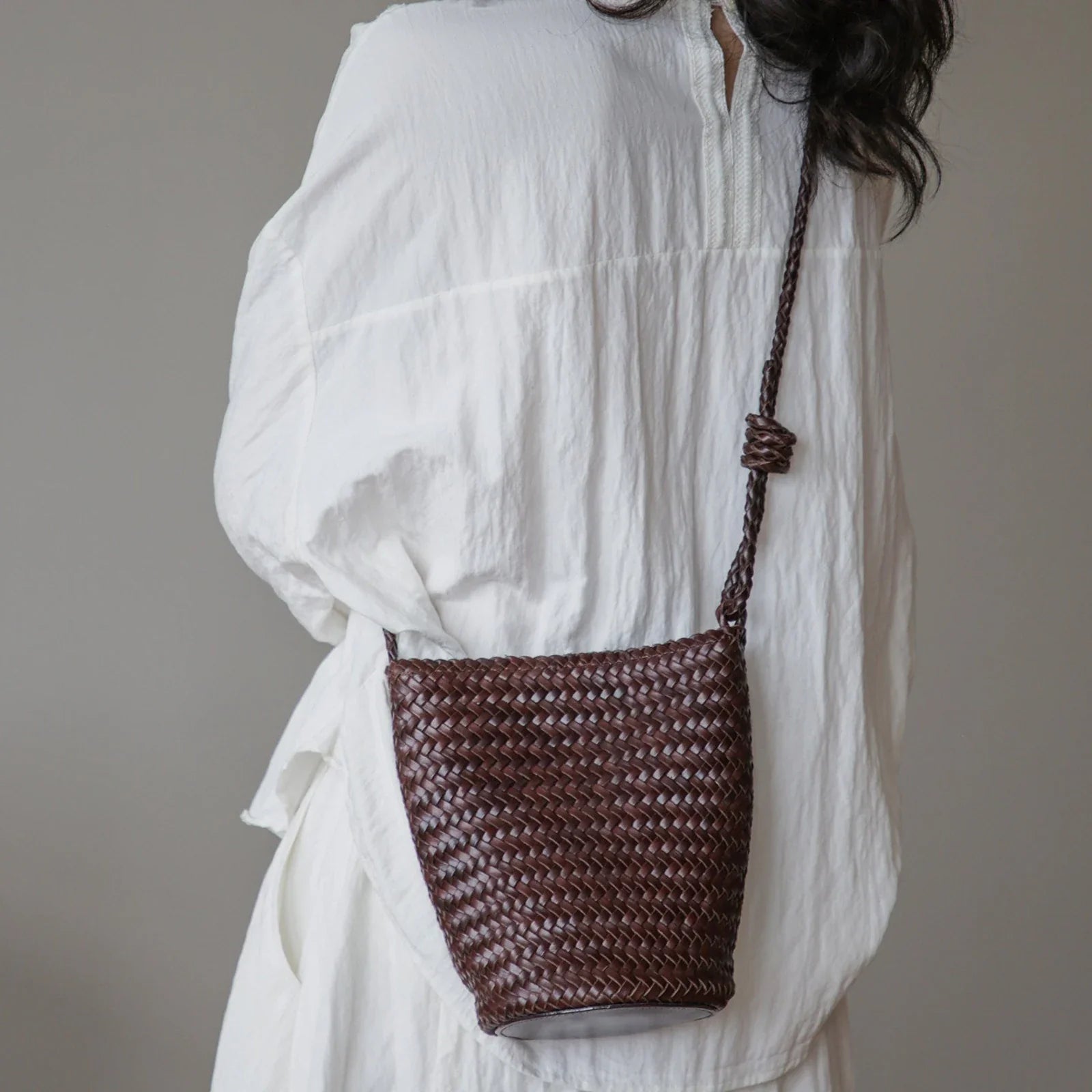 Coffee brown woven leather bucket bag styled crossbody