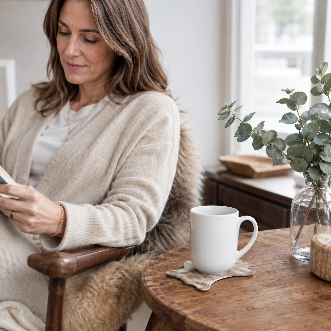 Woman seated beside a mug on a genuine cowhide silhouette coaster