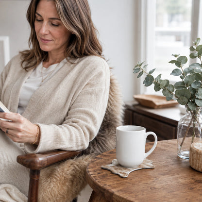 Woman seated beside a mug on a genuine cowhide silhouette coaster