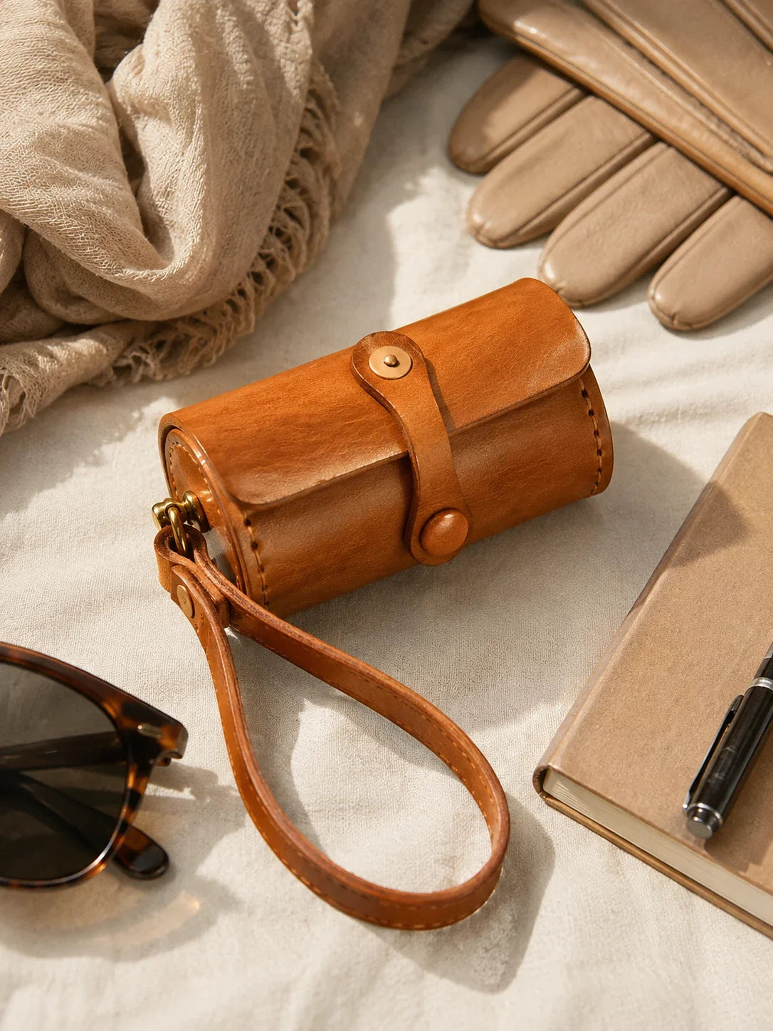 Sunset tan cowhide wristlet case arranged with travel accessories