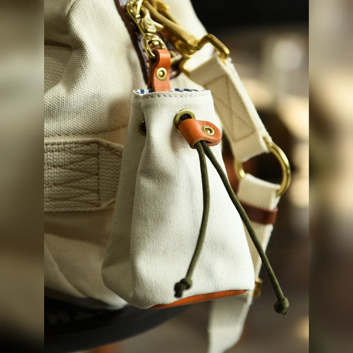 White drawstring storage pouch clipped to a canvas bag