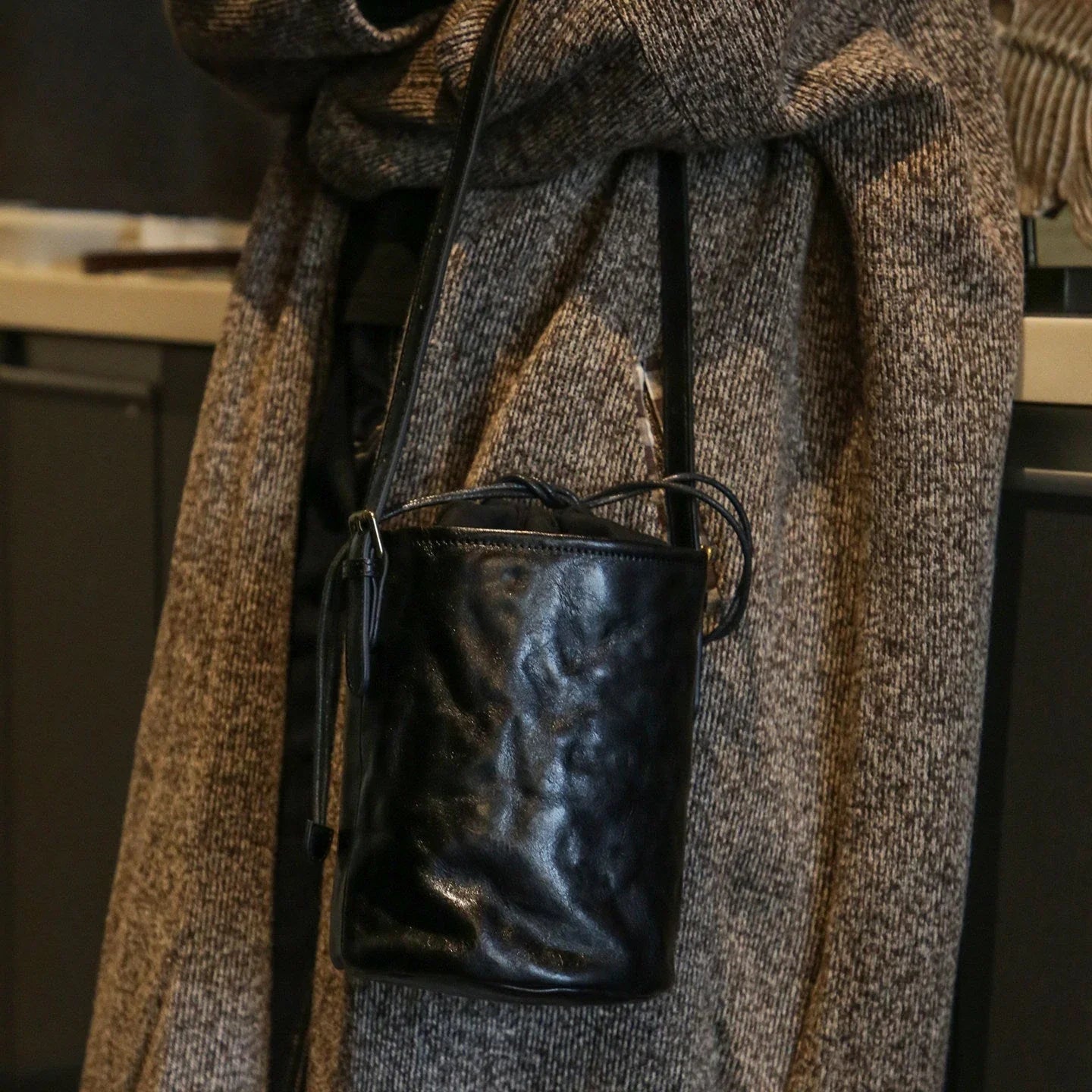 Front view of the black top-grain leather bucket bag