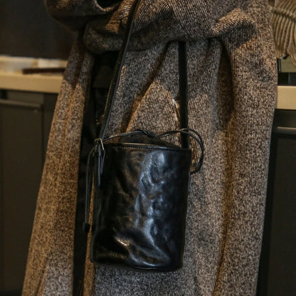 Front view of the black top-grain leather bucket bag