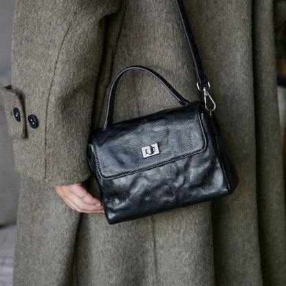 Black leather satchel worn with the detachable crossbody strap
