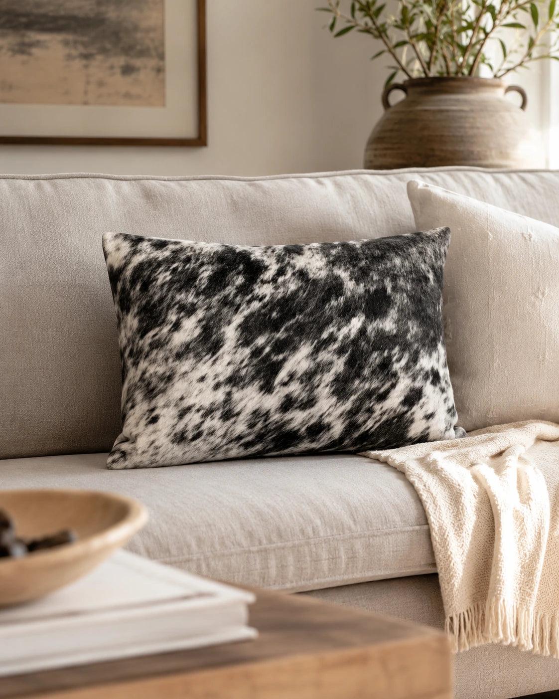 Salt-and-pepper genuine cowhide lumbar pillow styled on a neutral sofa