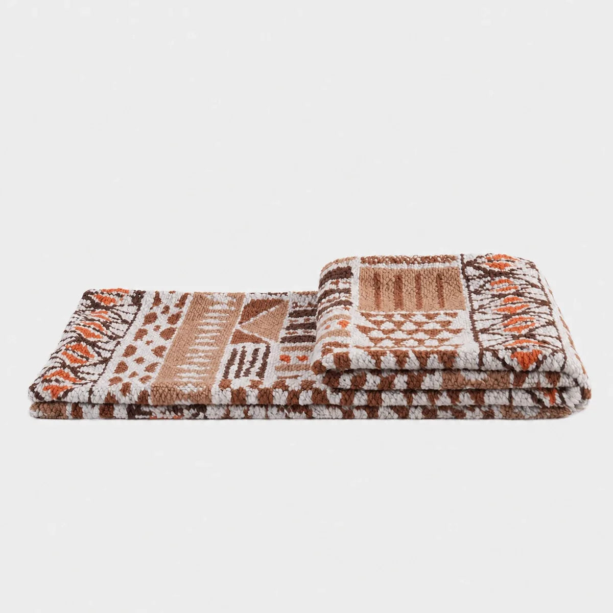 Folded mocha geometric textured throw on a light neutral background