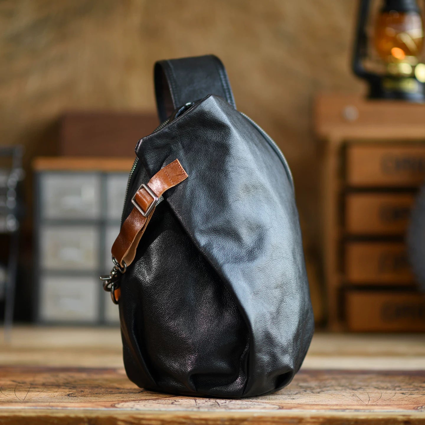 Black cowhide leather sling chest bag, studio product view