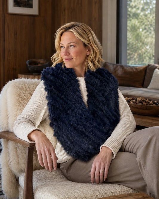 Navy blue rabbit fur knit poncho worn in a quiet reading room