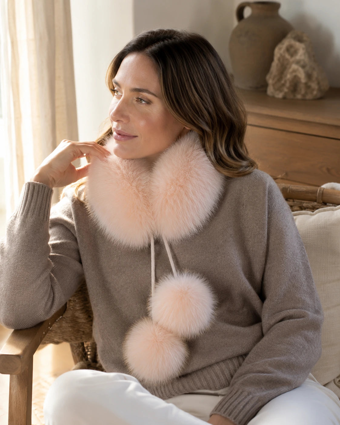 Woman wearing a Soft Pink genuine fox fur loop scarf in a warm interior