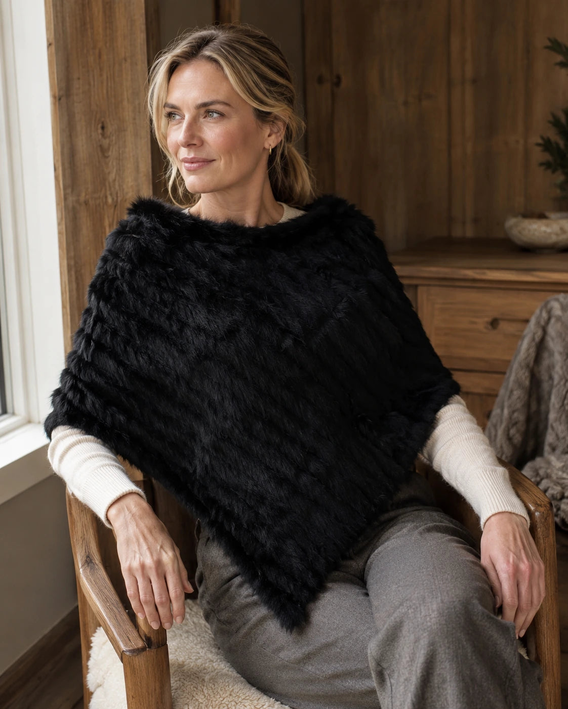 Black rabbit fur knit poncho worn in a naturally lit room