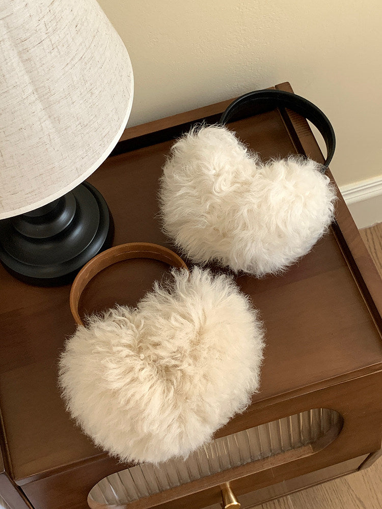 Camel and black wool earmuffs displayed together in a warm interior