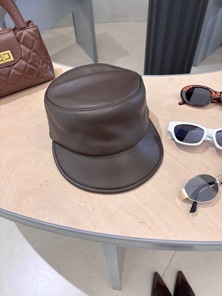 Brown smooth lambskin leather equestrian riding cap styled on a tabletop
