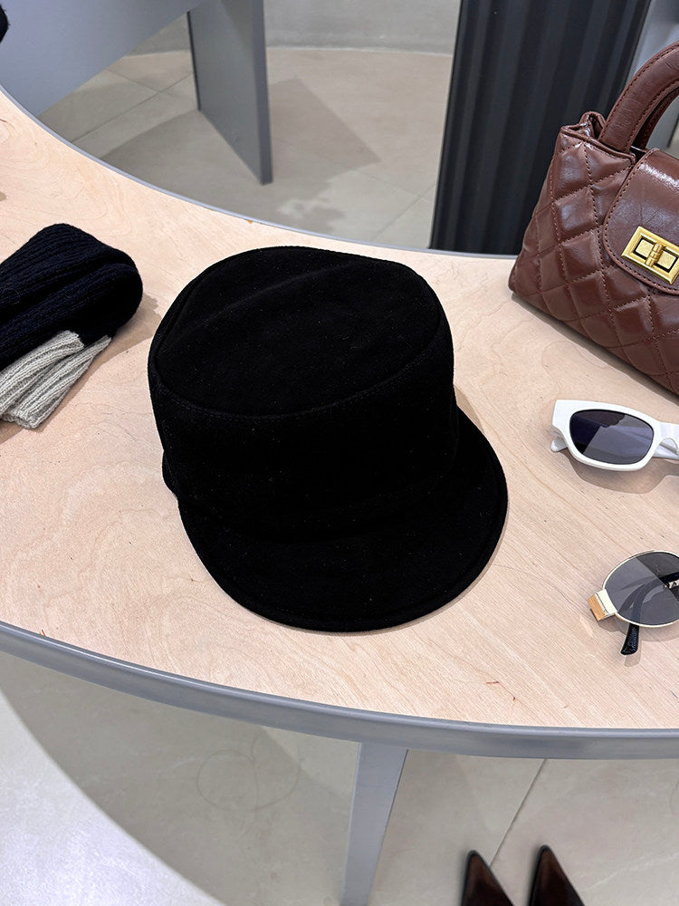 Black suede lambskin leather equestrian riding cap styled on a tabletop